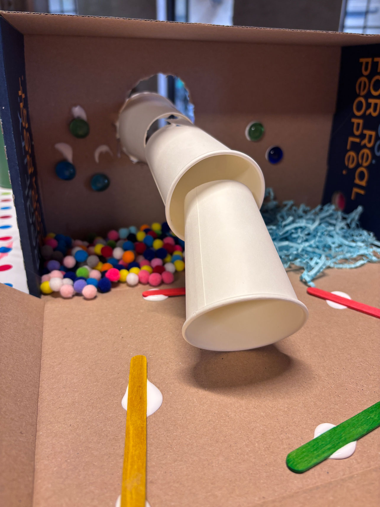 pappbox mit bunten Kugeln und Pappbechern
