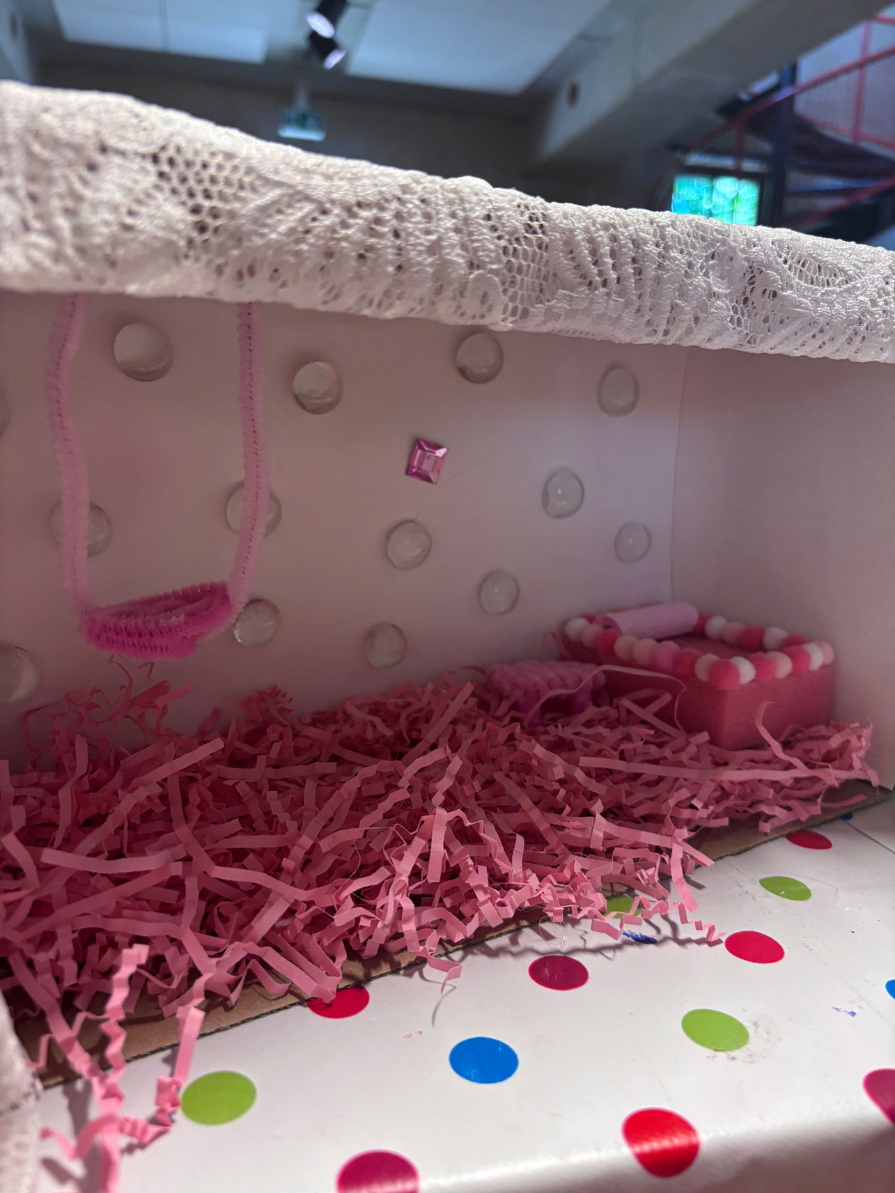 Pappkarton mit rosa Füllung und Glitzerperlen