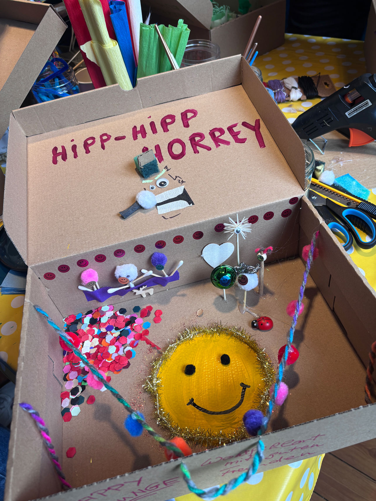 Box aus Pappe mit gelbem Smilie
